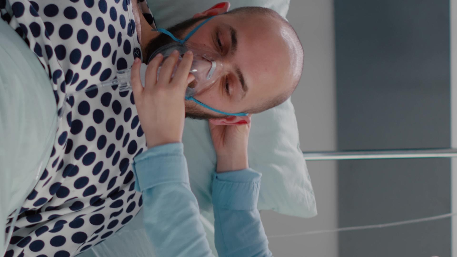 垂直视频关闭了病人在床上休息的病人医生使用氧气罩视频的预览图