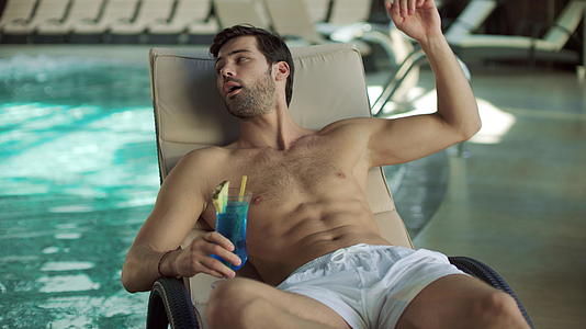 男人在游泳池附近喝鸡尾酒视频的预览图