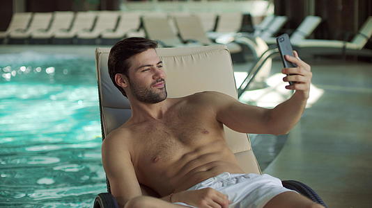 在室内游泳池附近玩手机自拍的人视频的预览图