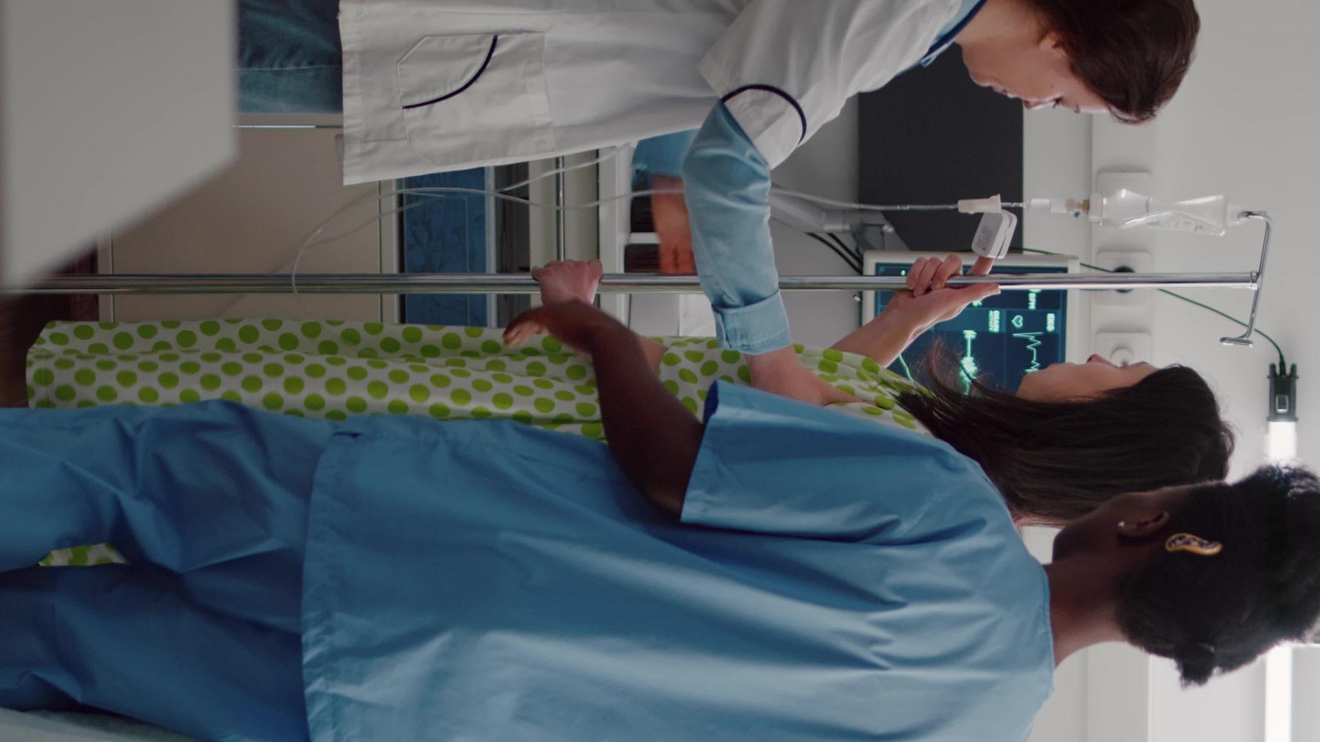 垂直视频医疗团队帮助患者从床上站起来抱静脉注射iv【竖版】视频的预览图
