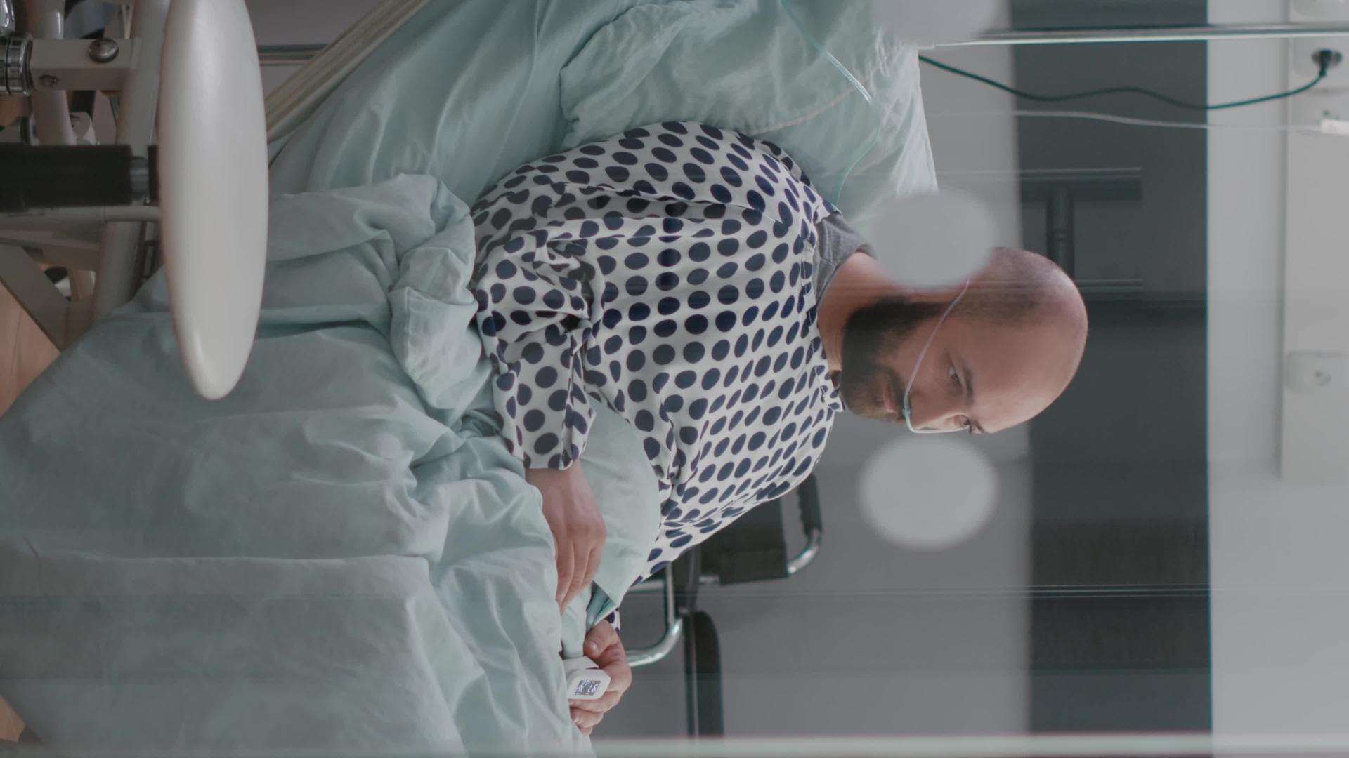 压力病男垂直版坐在床上等待呼吸治疗视频的预览图