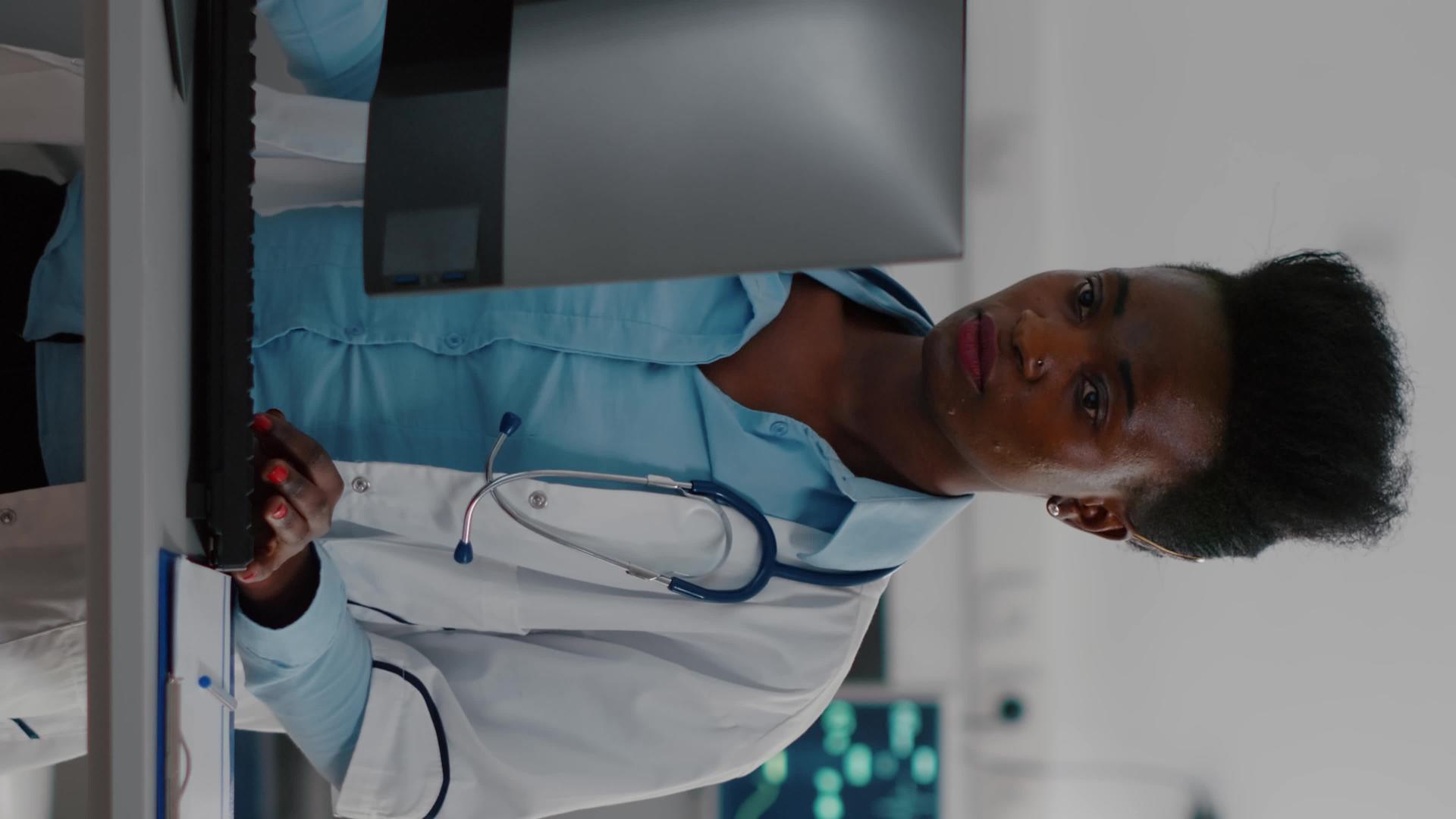 垂直视频美国医生在电脑上输入医学专业知识的正面视图视频的预览图