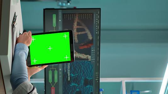 垂直视频化学家科学家坐在办公桌前使用绿色模拟屏幕视频的预览图