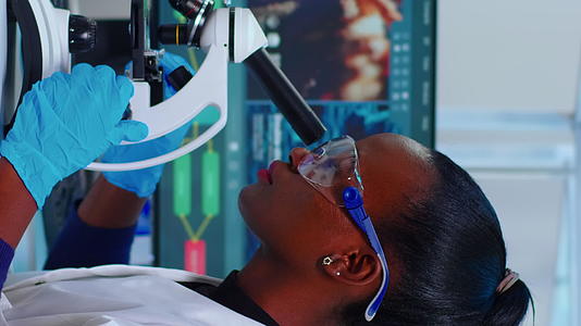 非洲女性生物化学家在实验室使用显微镜的垂直视频视频的预览图