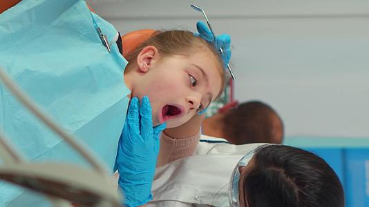 垂直视频为小女病人提供带口罩的儿科牙医视频的预览图