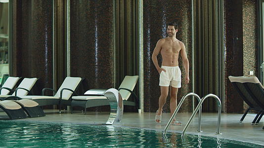 在豪华酒店游泳池旁放松的男人视频的预览图