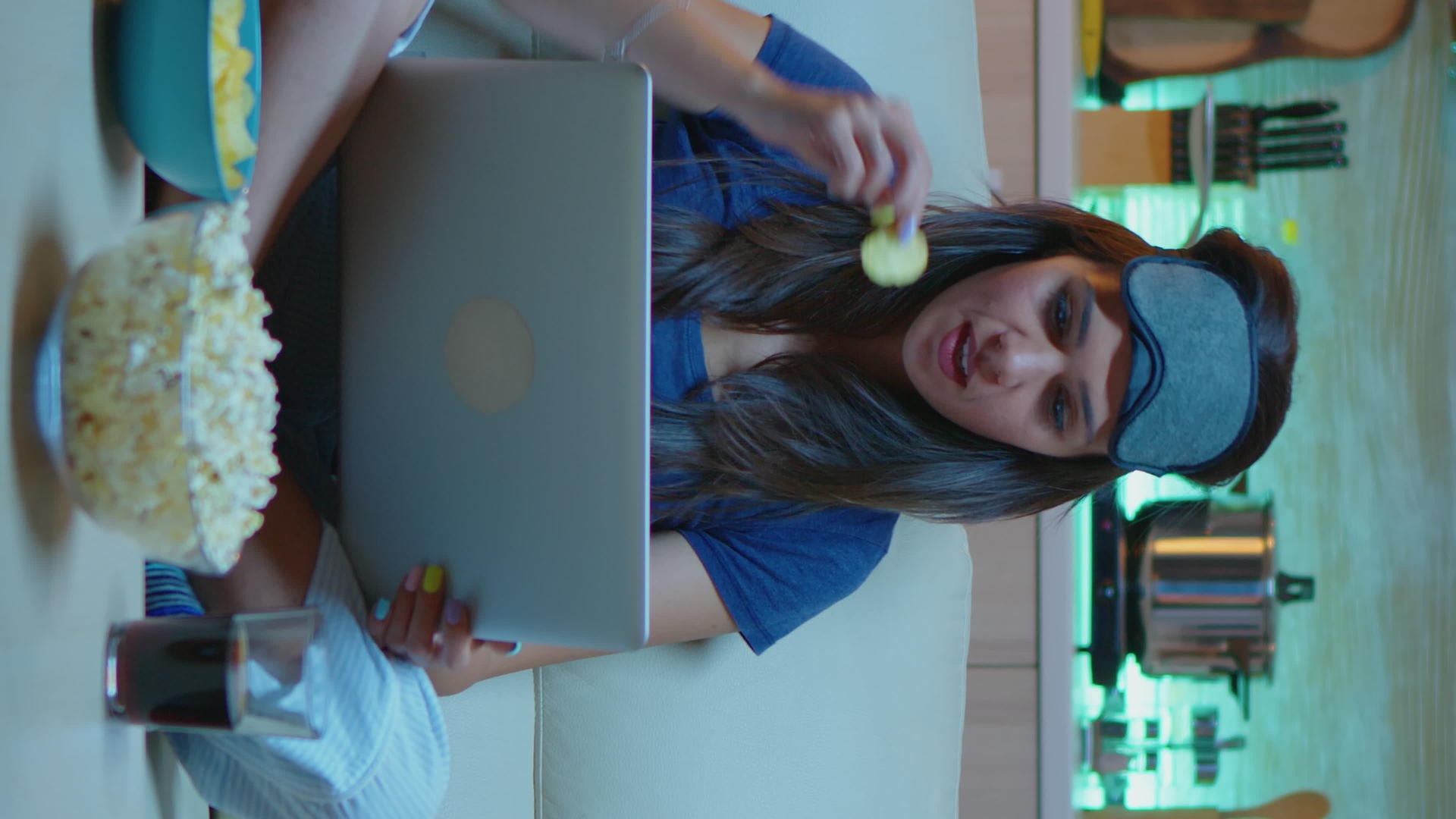 女性夜间使用笔记本电脑和戴眼罩的垂直视频视频的预览图