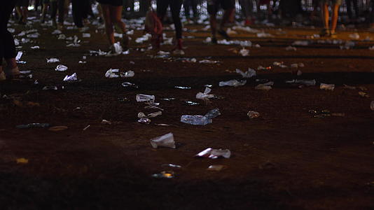 音乐会结束后人们在地上的塑料杯上走来走去视频的预览图