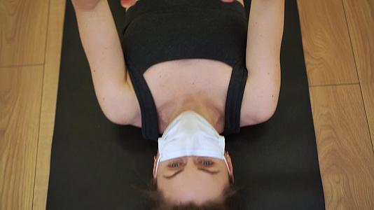 女性在健身房戴口罩锻炼视频的预览图