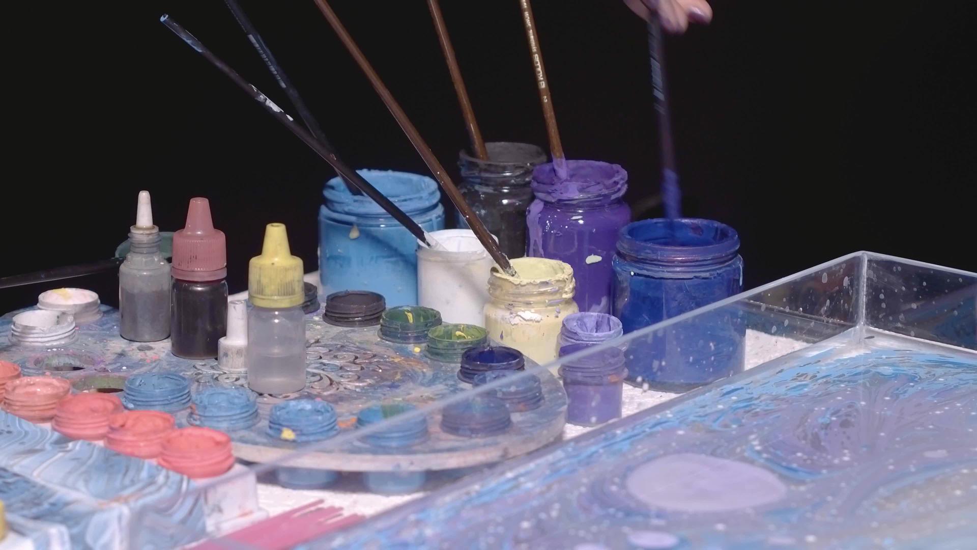 艺术家用蓝色和紫色油漆创造抽象艺术视频的预览图