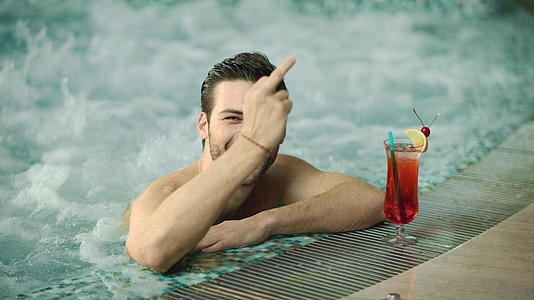 在游泳池里放松快乐的男人在浴池里笑视频的预览图