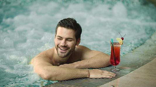 性感的男人在温泉酒店的游泳池里放松视频的预览图