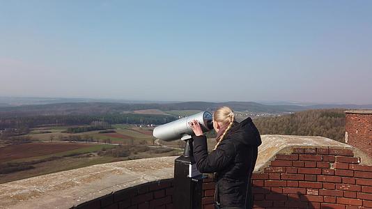 使用望远镜在古城堡附近的山谷中寻找女性旅行者视频的预览图