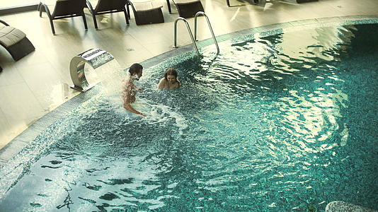 游泳池里的年轻夫妇享受水疗视频的预览图