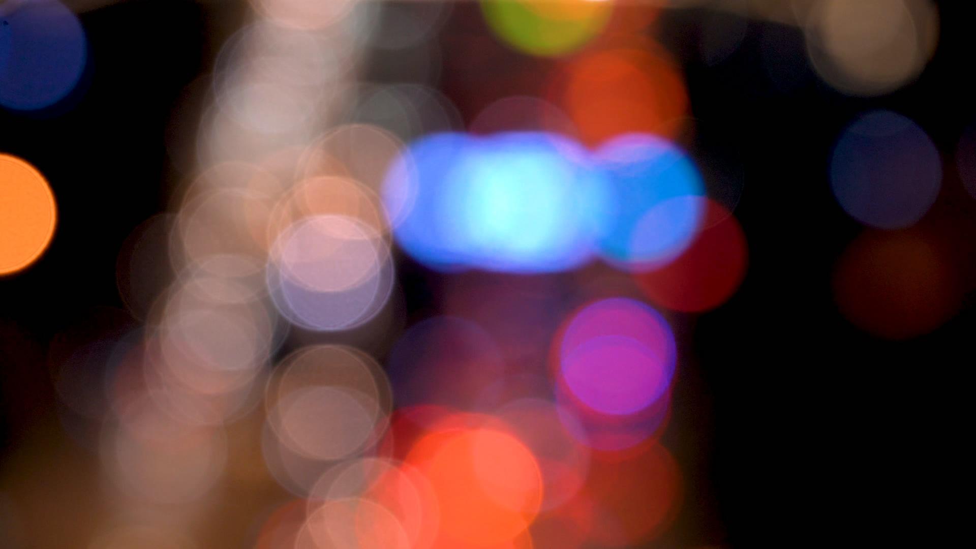 4K虚焦都市夜晚行驶中的车流五颜六色的光斑视频素材视频的预览图