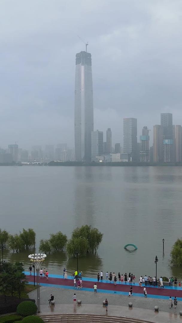 长江洪峰过后航拍风景城市在堤坝上看到河水上升的游客群体素材视频的预览图