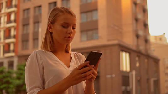 在户外使用智能手机的女性商人视频的预览图