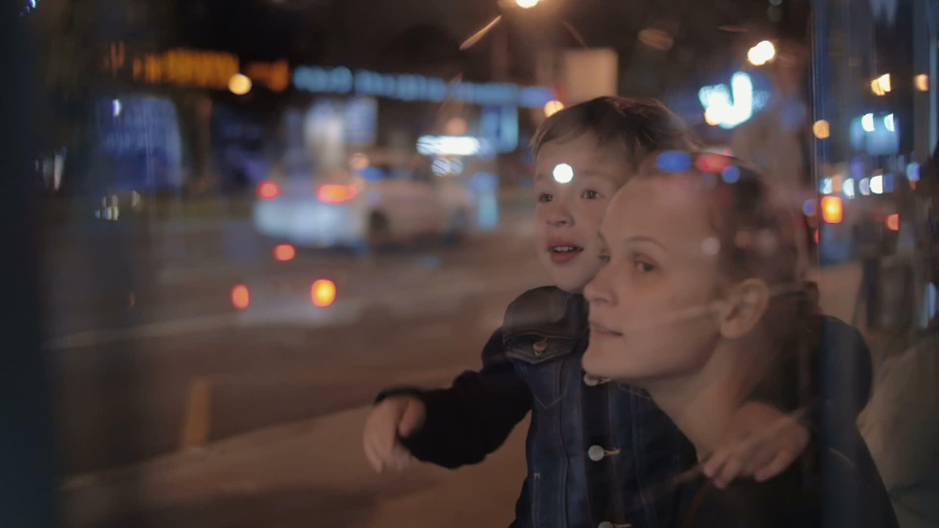母亲和好奇的儿子在夜晚的城市里视频的预览图