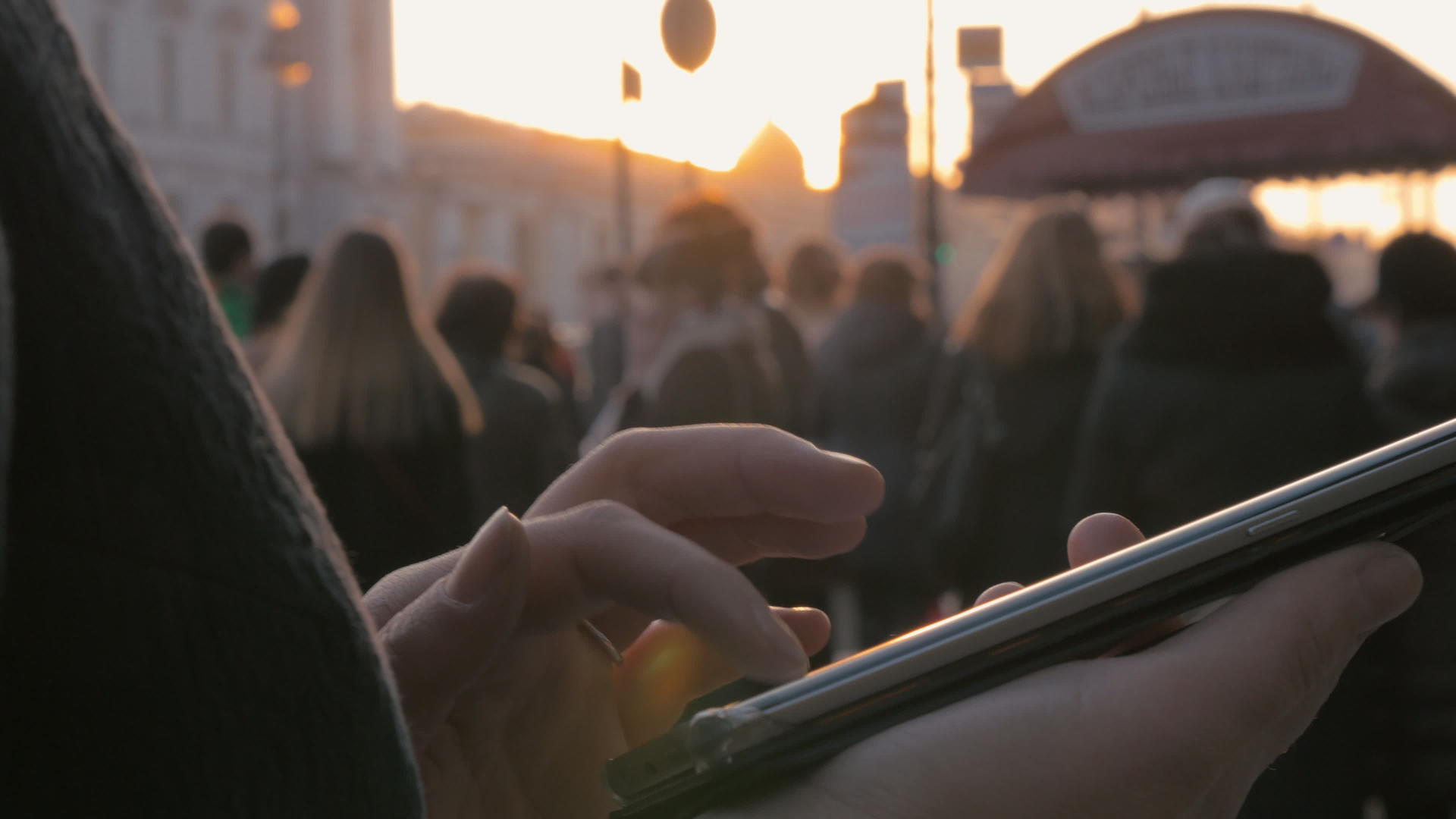 城市妇女在日落时使用手机视频的预览图