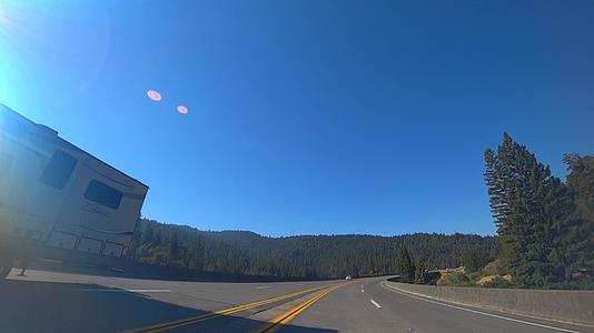 摄像机从一辆汽车上看到它沿着美丽的风景道路快速行驶视频的预览图