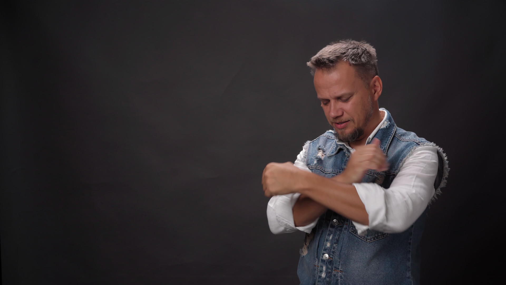 一名身穿牛仔背心的男子交叉双臂祈祷双手竖起大拇指双臂伸出双臂视频的预览图
