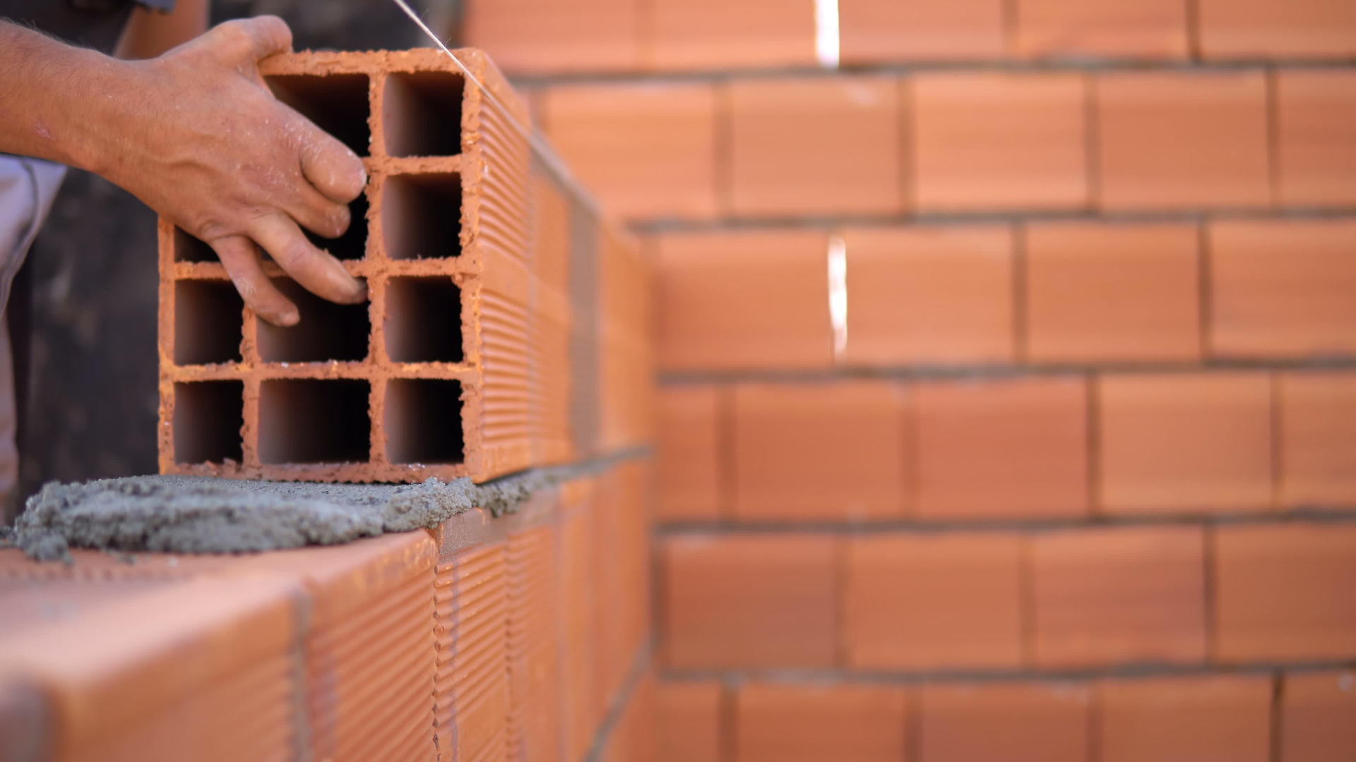 砖匠在建筑工地上铺砖形成建筑墙视频的预览图