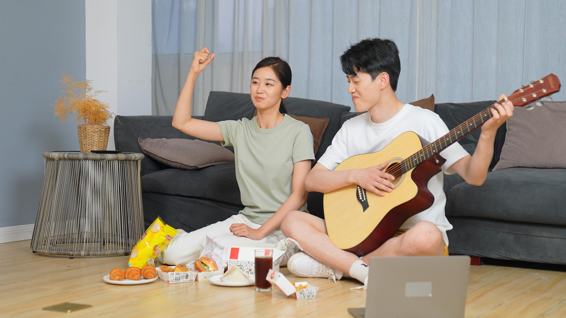 年轻夫妇在家吃零食看电视视频的预览图