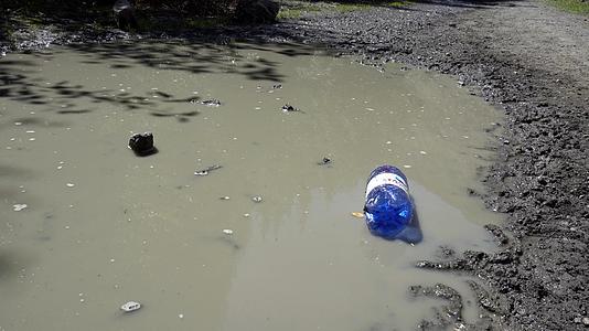 塑料瓶躺在泥坑里在泥坑里视频的预览图