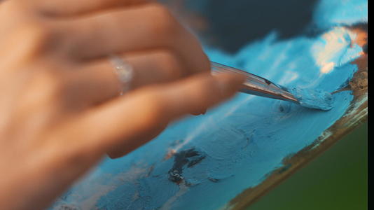 女画家将调色板上的油漆与刷子混合手工绘画技巧视频的预览图