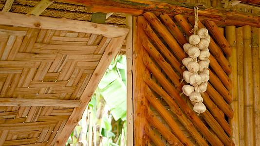 干大蒜挂在传统的亚洲房屋的竹墙上视频的预览图