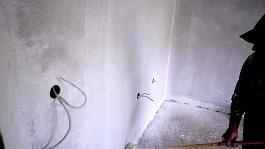 一名男子在墙上画了一面墙来修复公寓视频的预览图