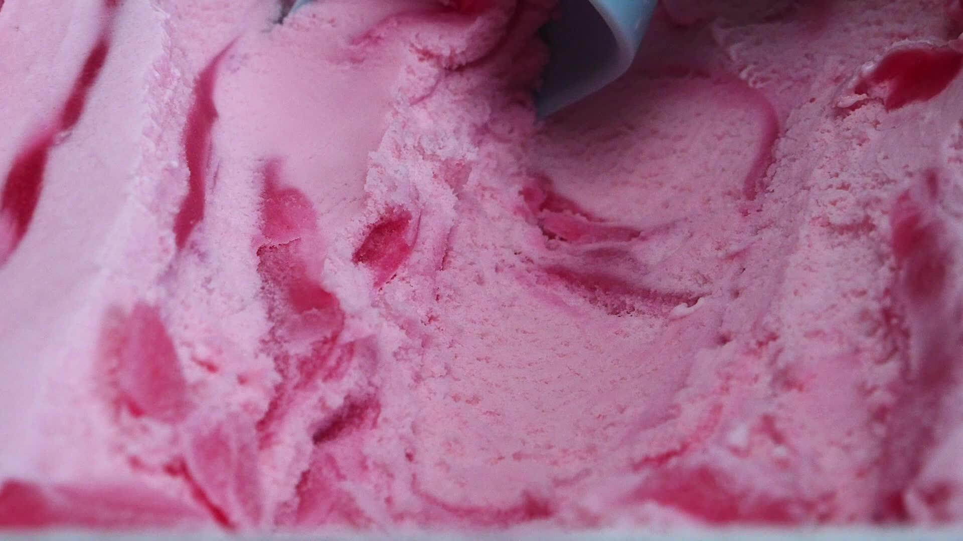 用勺子从容器里拿出冰淇淋草莓放在前门看食物的概念视频的预览图