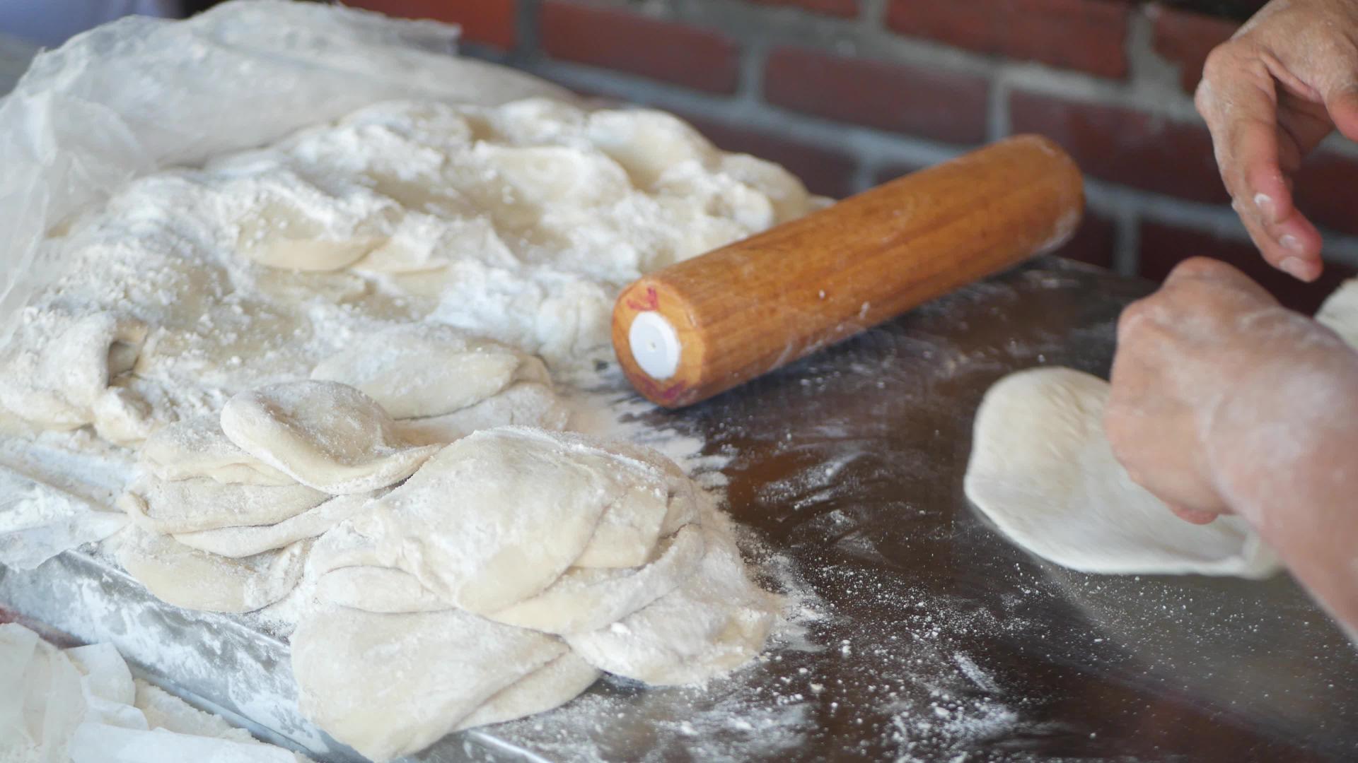 女人用擀面杖在面粉里揉面团做墨西哥玉米饼准备拉丁美洲玉米饼视频的预览图