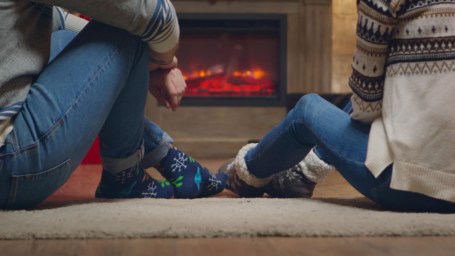 年轻夫妇在壁炉前穿暖袜子视频的预览图