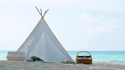 4k浪漫的白色野餐帐篷在白色沙滩上与菜篮子食物搭配视频的预览图