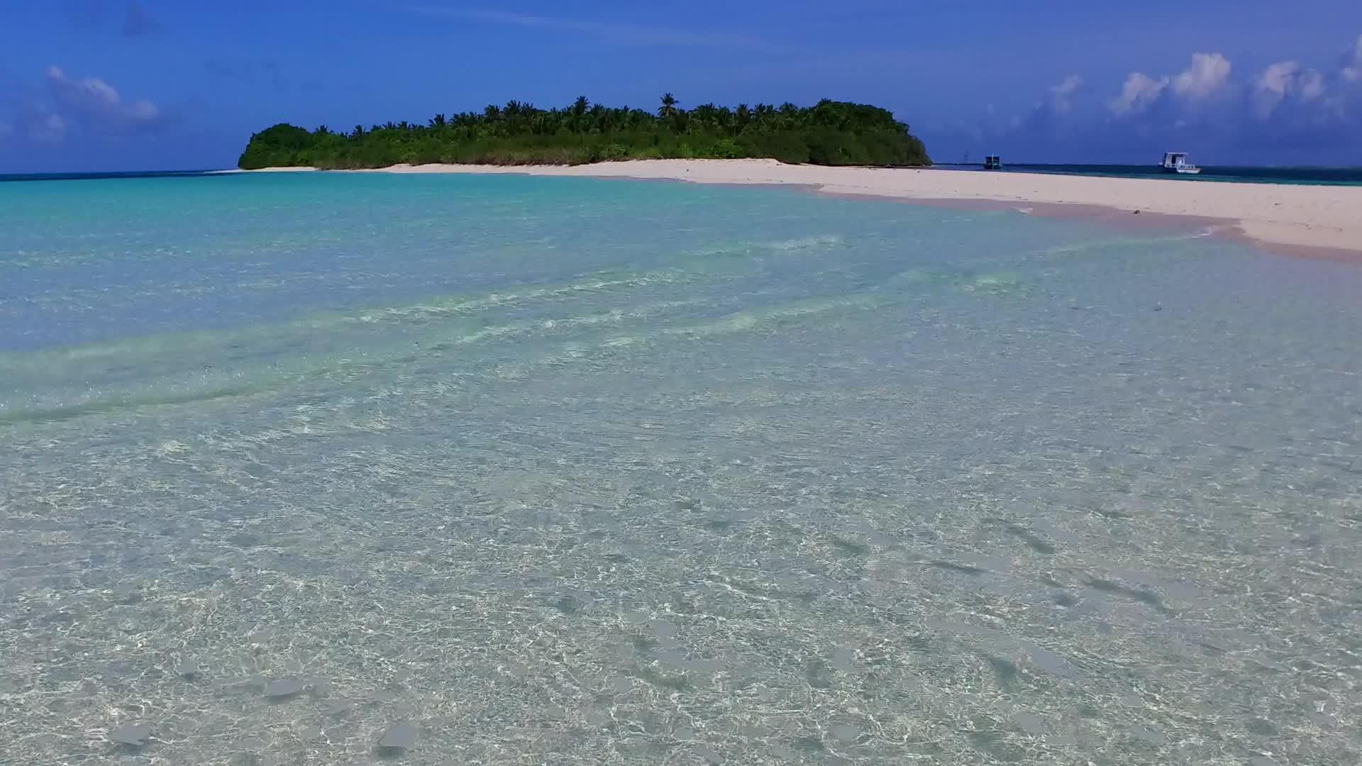 阳光下透明泻湖和白沙的海滨海滩生活方式视频的预览图