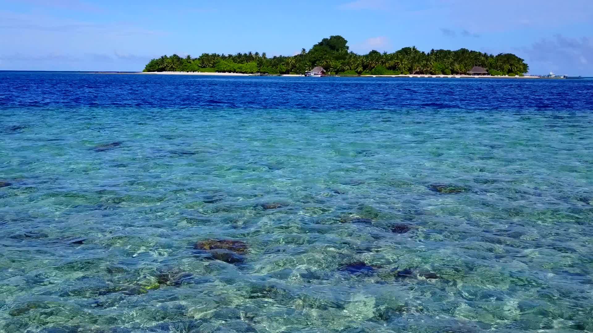 阳光由水蓝环礁湖和度假胜地附近的浅沙背景组成视频的预览图