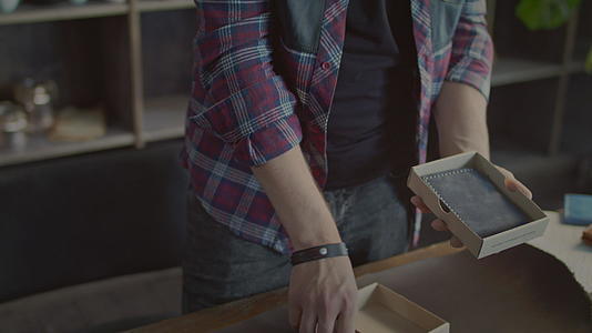 男性手工产品在小零售店纸箱袋包装视频的预览图