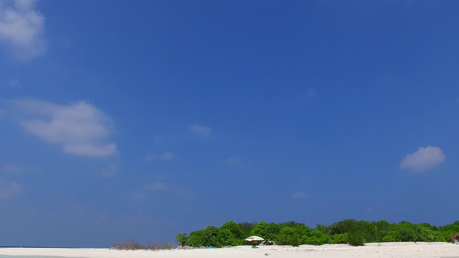 以透明的海面和白色的沙子为代表的白色沙子在阳光下视频的预览图