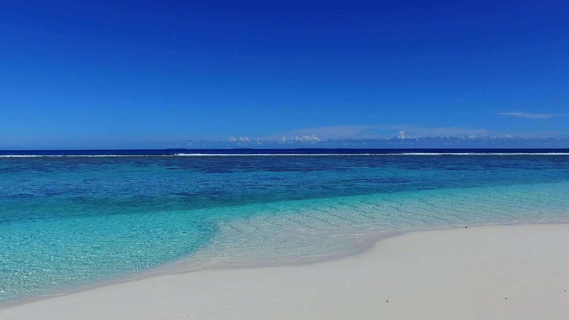 在蓝色的环礁湖棕榈树附近有一个白色的沙滩背景视频的预览图