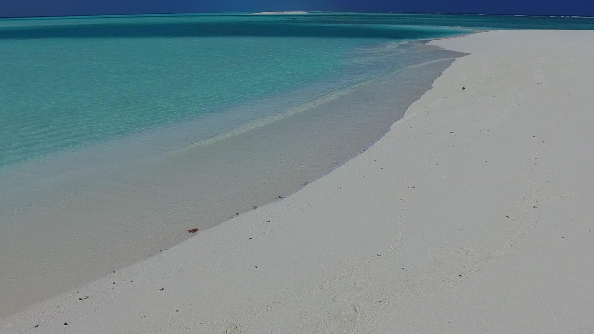 蓝海打破了海滩海滩附近有白色的沙滩背景视频的预览图