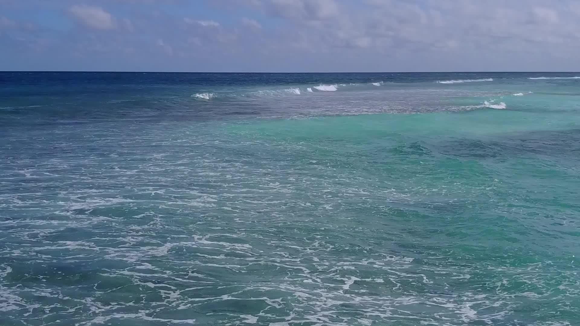 蓝色清澈的海洋在棕榈树附近的白色沙滩上视频的预览图