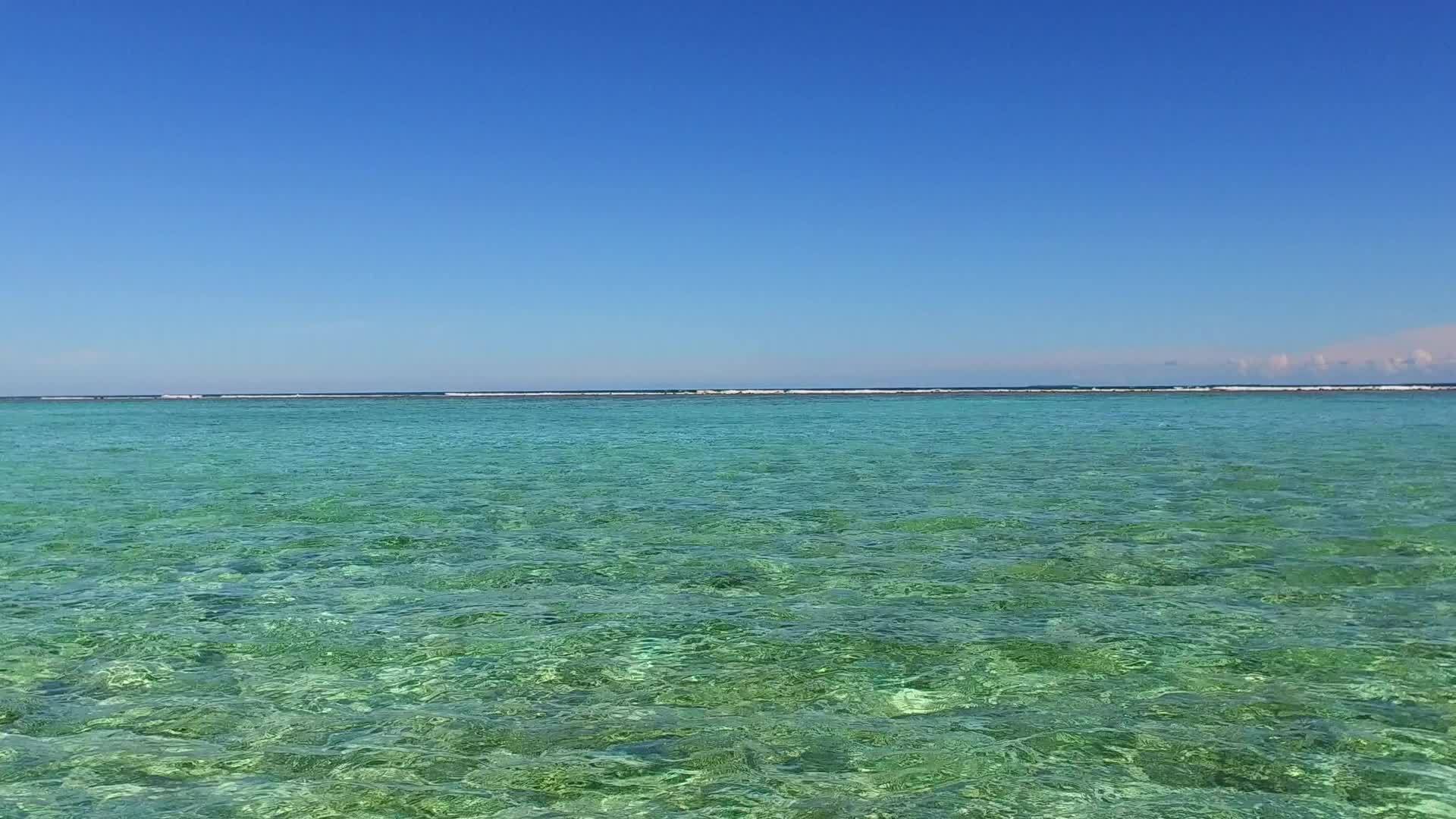 在透明的海洋中海滩附近有一个白色的沙底背景有一个安静的环礁视频的预览图