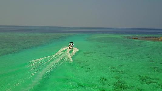 蓝色的海面上阳光下有白色的沙子背景驾驶着一艘小船视频的预览图
