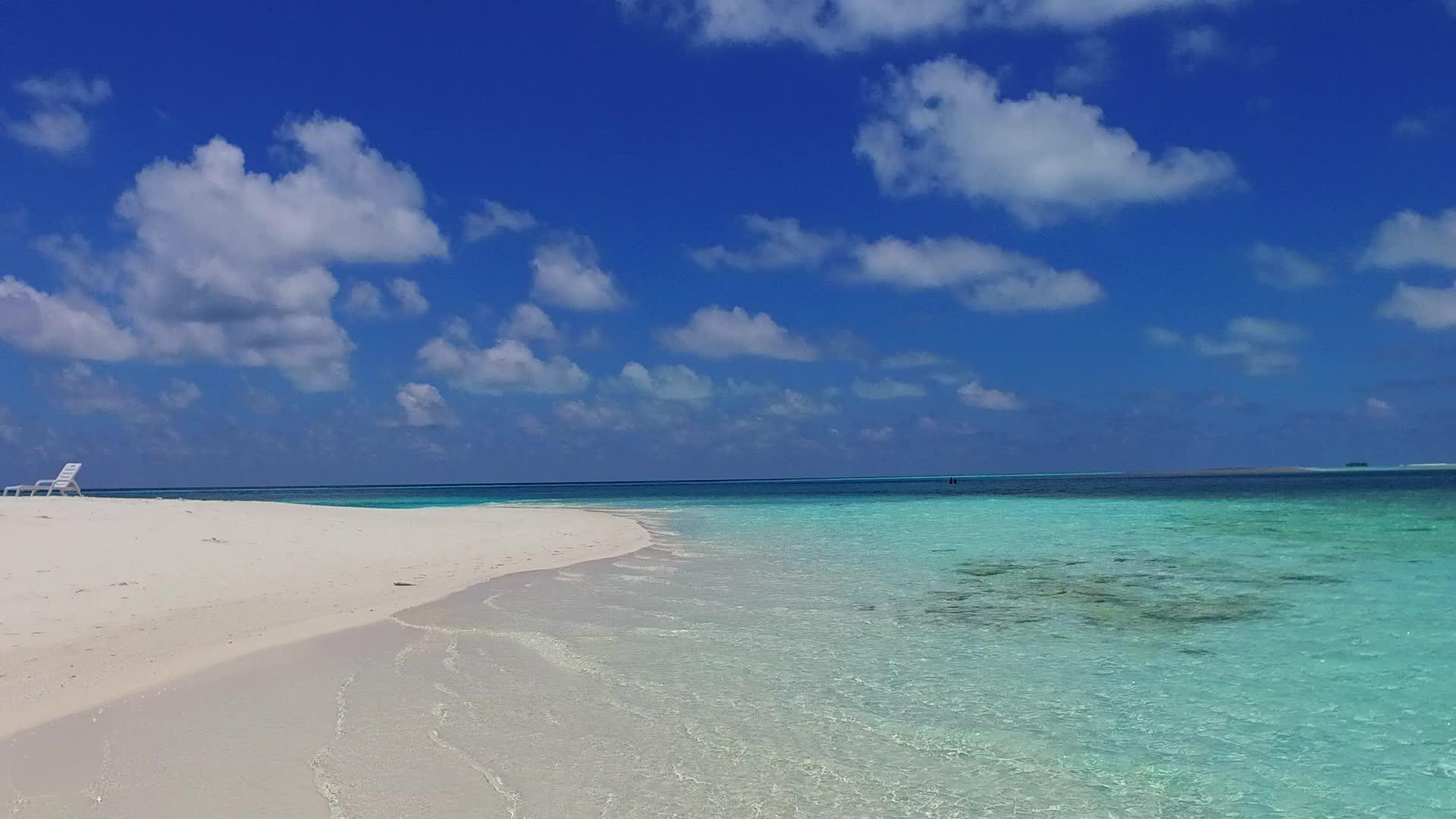 利用蓝水和珊瑚礁附近的白色海滩背景关闭外国度假胜地海滩视频的预览图