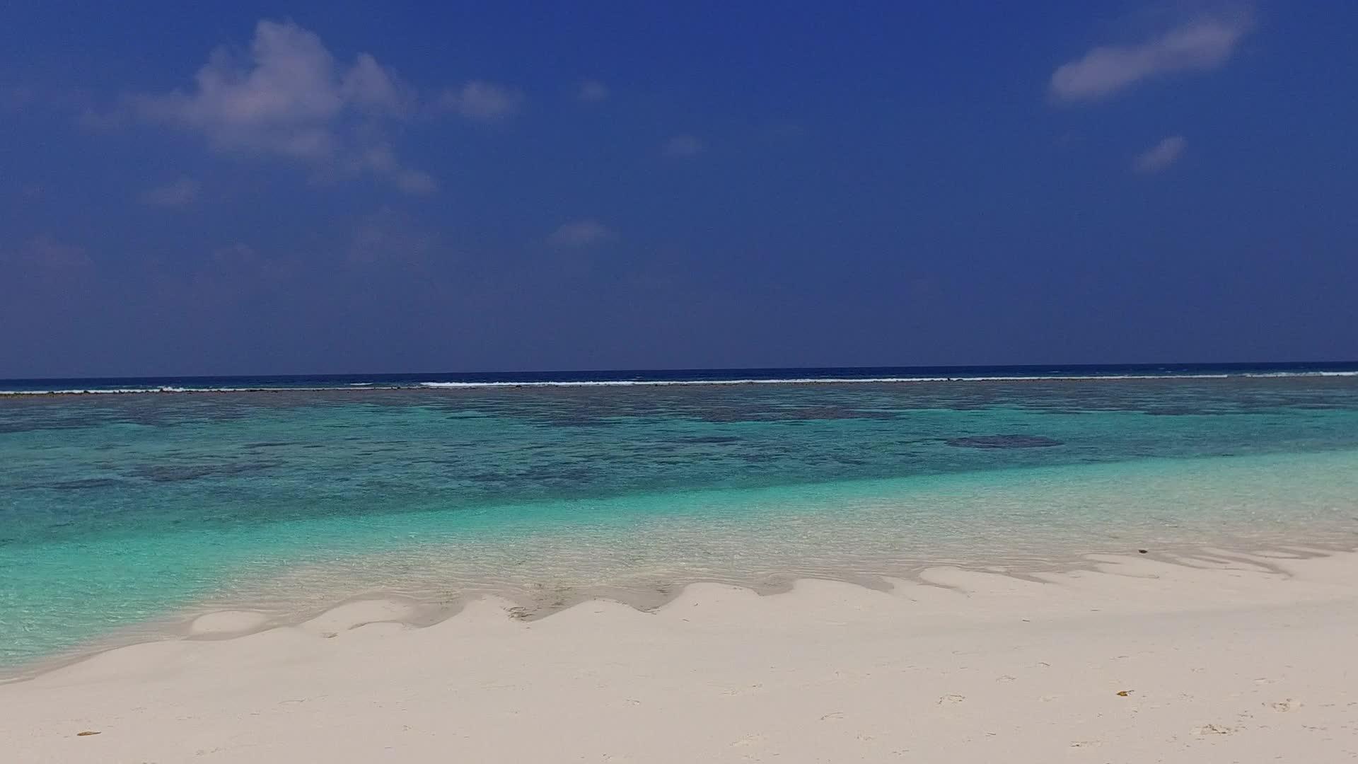 清澈的海洋和接近冲浪的浅沙背景下的空海滩探险模式视频的预览图