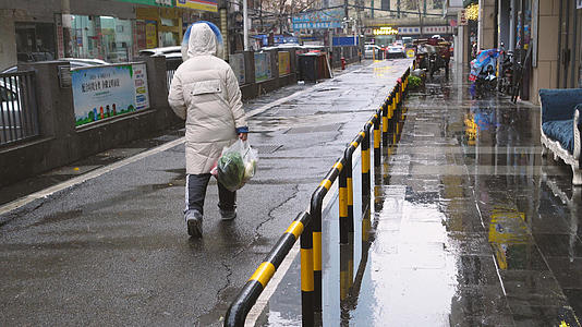 城市冒雪降温拎着塑料袋女性背影4k环保素材视频的预览图