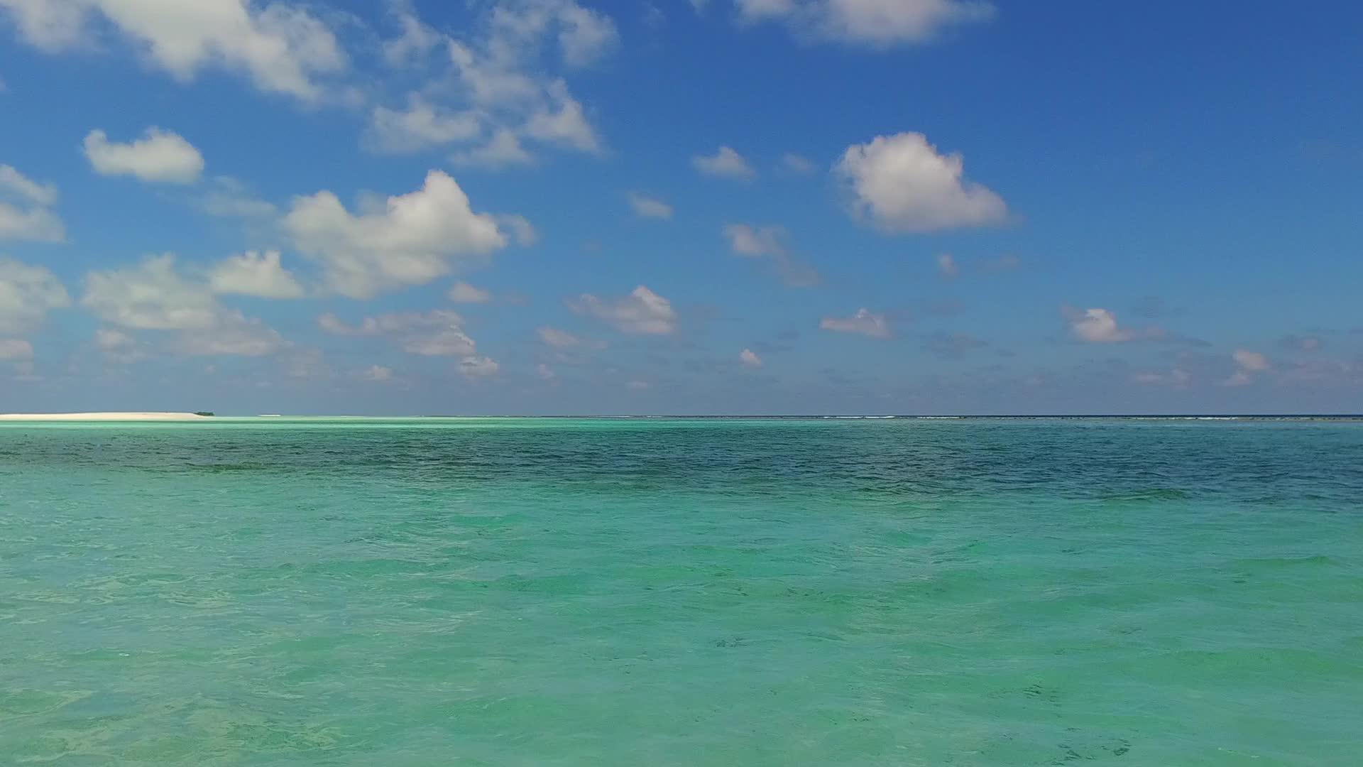在透明的海面上沙滩附近有明亮的沙滩背景打破了宁静的环礁视频的预览图