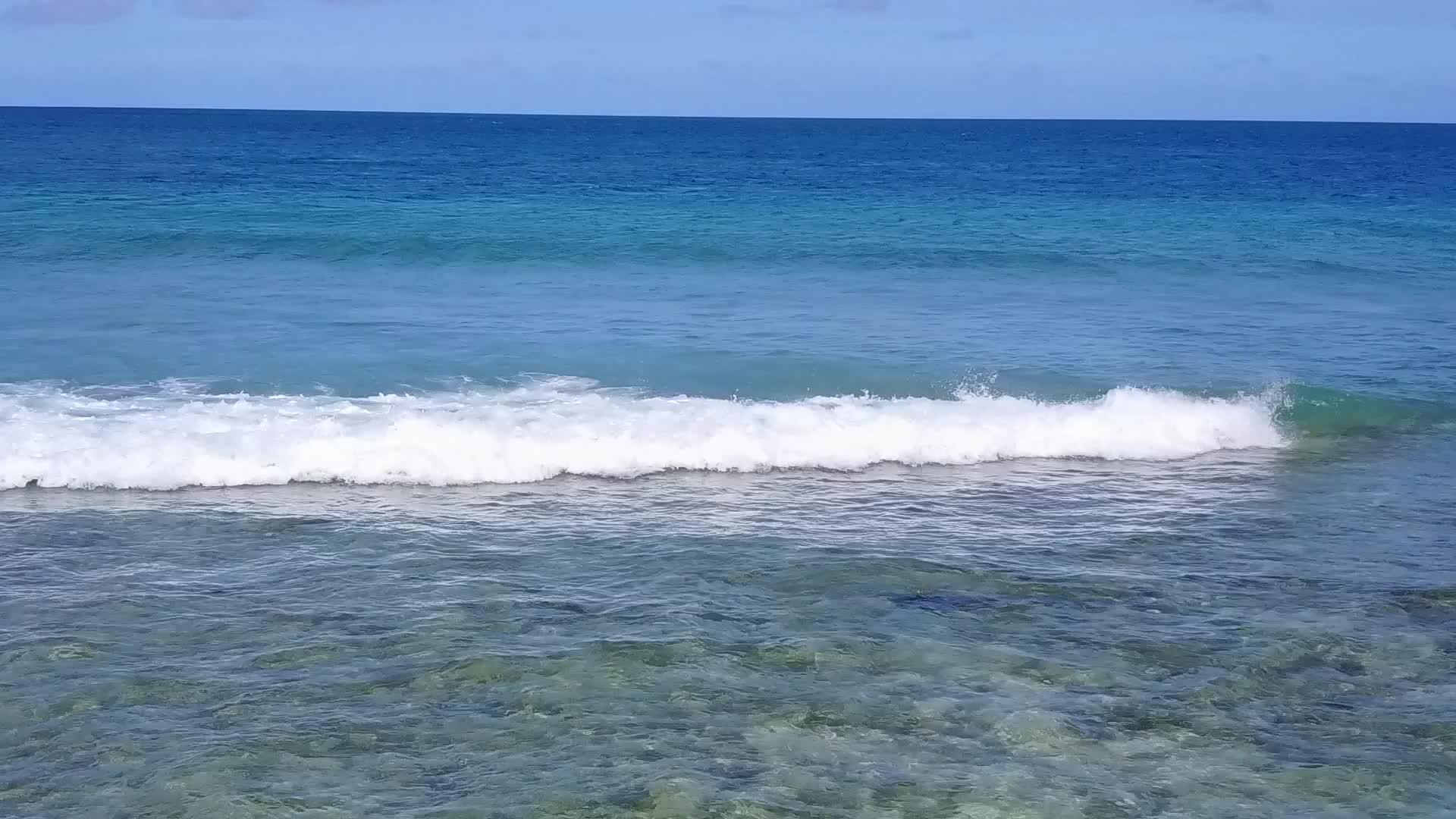 日出后蓝色的海水和明亮的沙质背景特写了豪华度假村海滩海滩视频的预览图