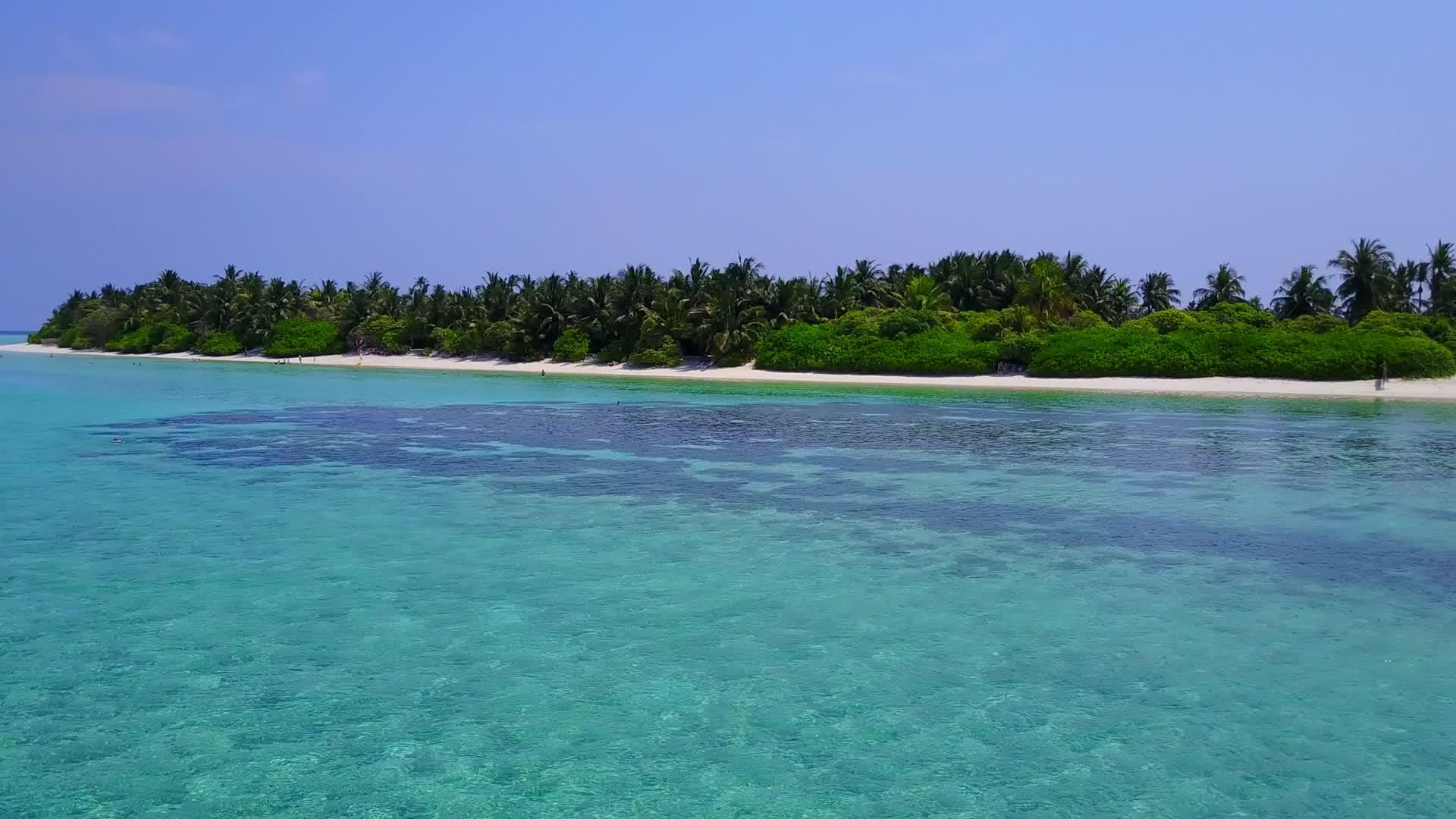 蓝色的海洋和珊瑚礁附近的白沙本背景的蓝色海洋是一个安静的度假胜地视频的预览图